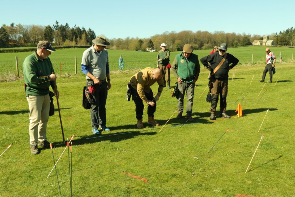 Archers gathered on the clout field checking where arrows have landed